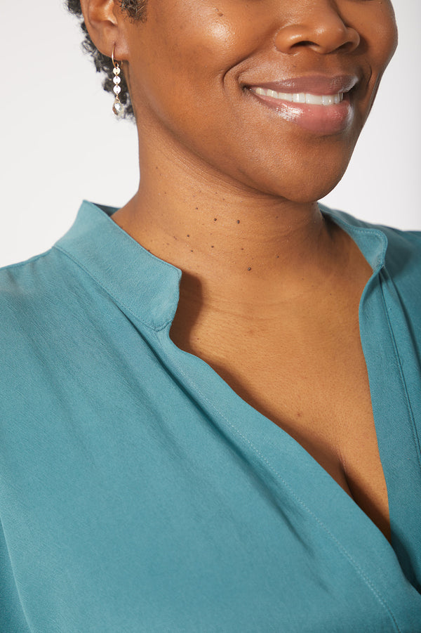 Close up of beautiful black woman wearing Dessous Loungewear's Bianca caftan midi dress in sustainable Lyocell turquoise fabric.