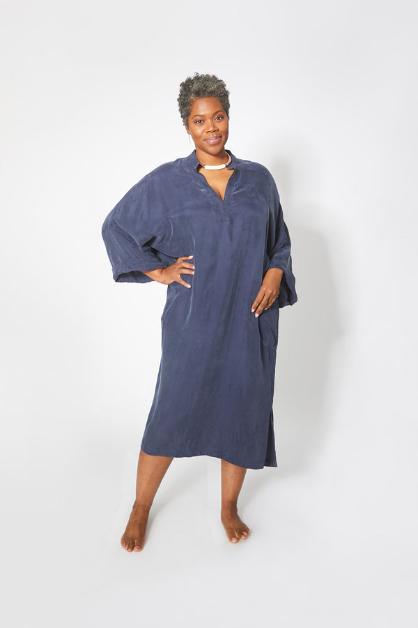 Beautiful black woman wearing Dessous Loungewear Bianca caftan in navy sustainable Cupro fabric. 