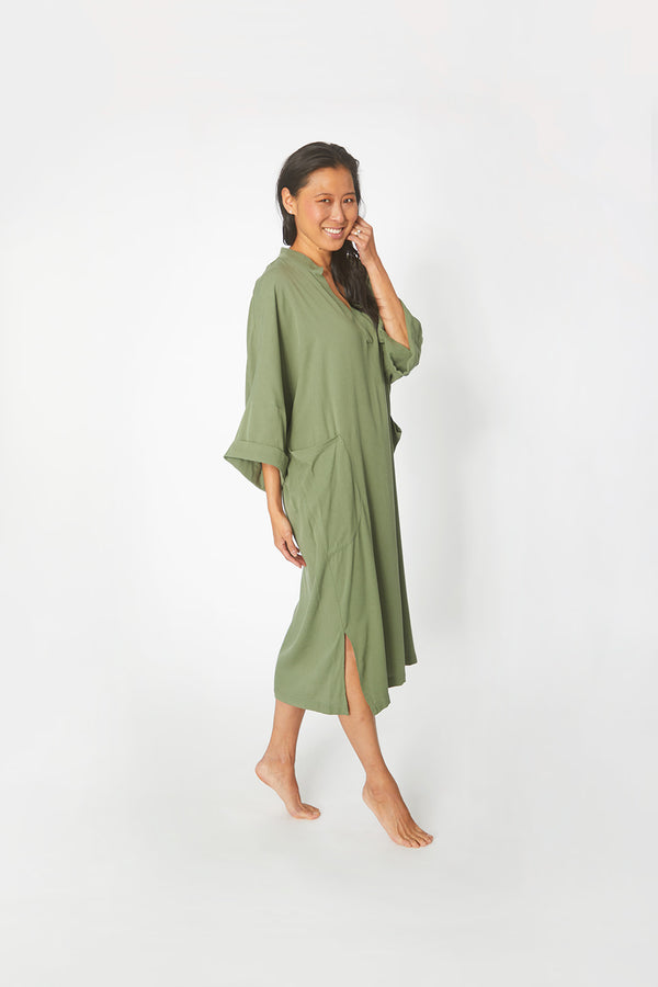 Side view of Beautiful Asian woman wearing Dessous Loungewear Bianca Caftan in moss green sustainable Lyocell fabric.