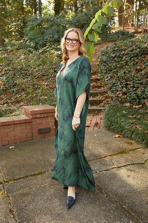 Woman wearing green and navy marble print, maxi-length sustainable caftan.
